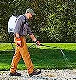 Man Spraying Weeds with Automatic Battery Backpack Weed Sprayer and Long Spray Wand